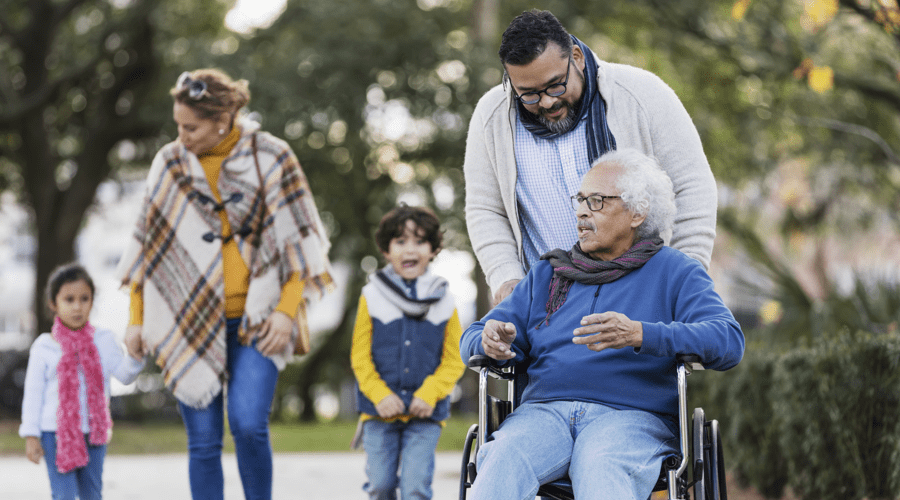 man in wheelchair with family